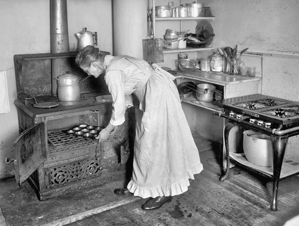 Historical illustration of a domestic cook working in an early 1900s kitchen